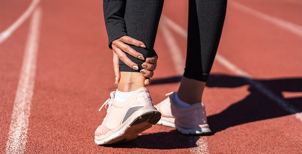A woman in narrow toe running shoes with a sore ankle